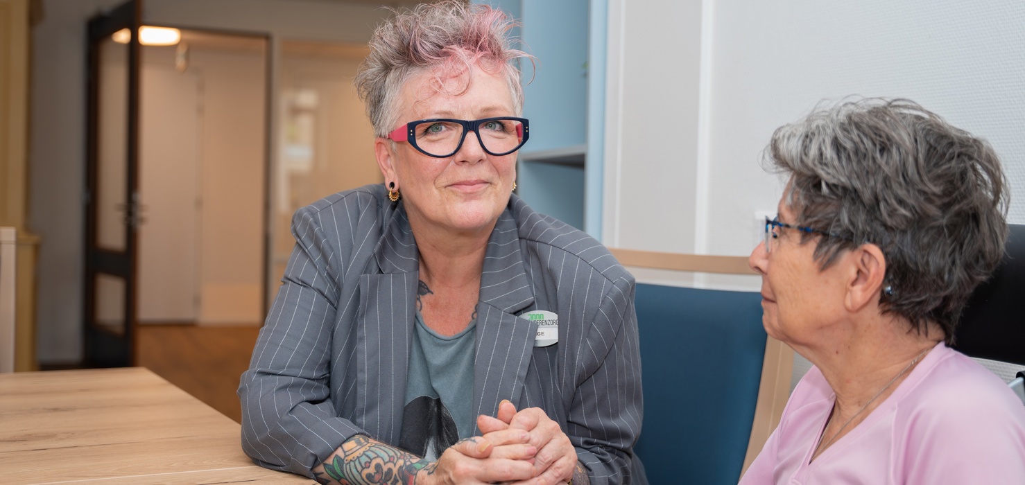 Inge (welzijnswerker) houdt hand vast van bewoonster Inge is welzijnsmedewerker bij Anna Ouderenzorg